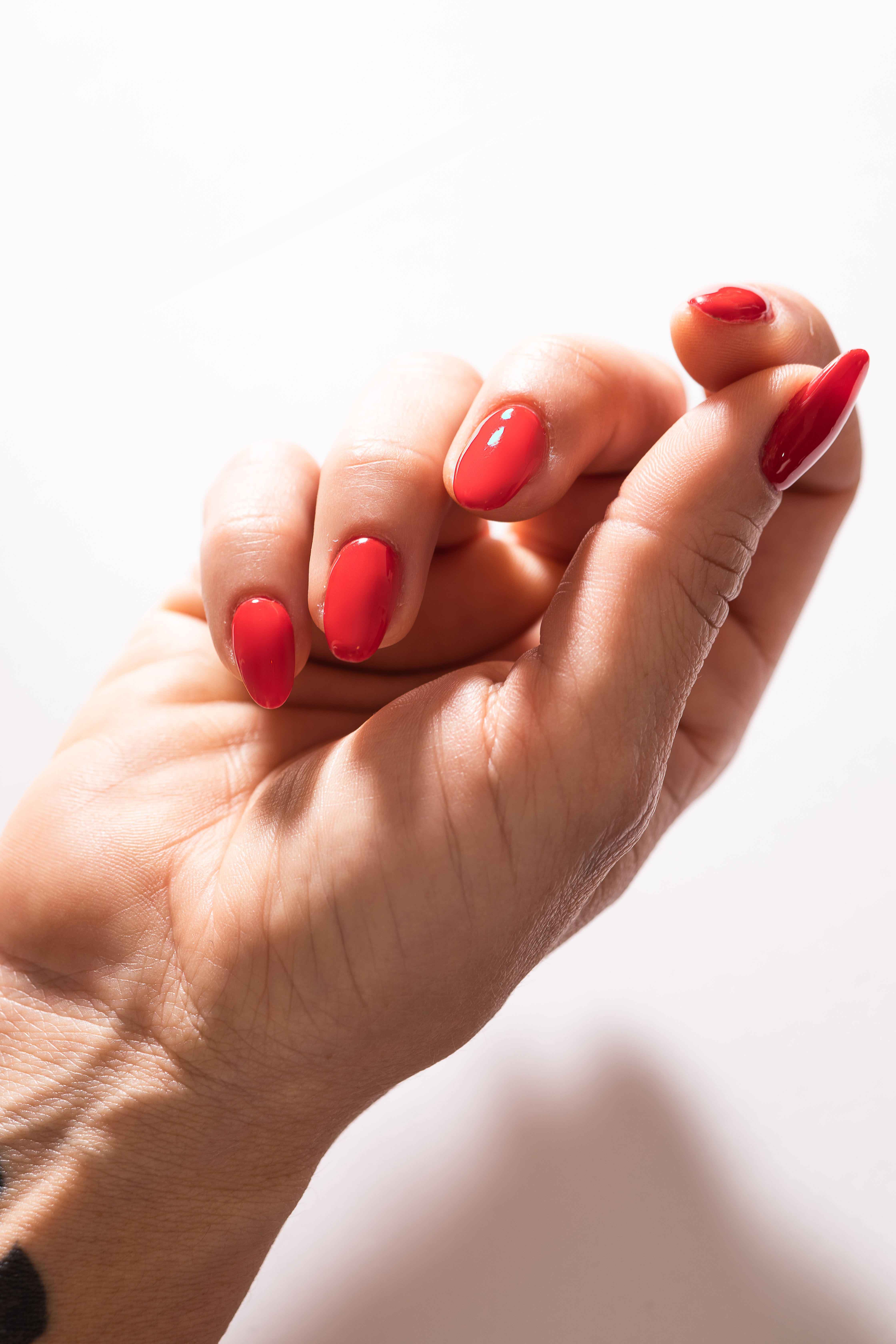 Close-up of a glossy red manicure, photographed by Andrea Mosti
